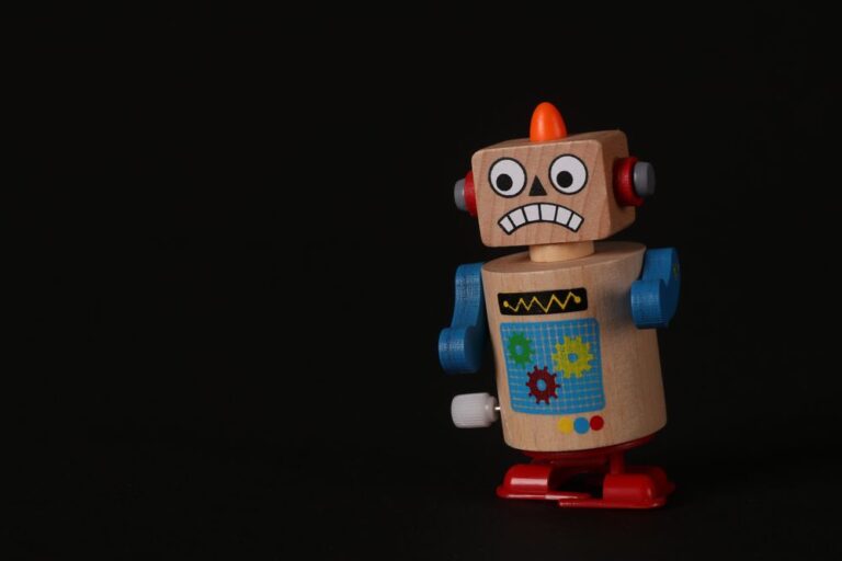 A vintage wind-up toy robot figure on a dark background